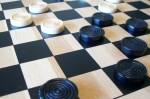 
						Jogo de estratégia abstrata, onde os jogadores movem as peças em forma de disco através de um tabuleiro 8x8 quadriculado.<br />
As peças só se movem na diagonal, e apenas um espaço de cada vez. Se um jogador mover uma de suas peças de modo que -salta- uma peça do lado de seu adversário e em um espaço vazio, o jogador captura o disco do adversário. <br />
Pular movimentos devem ser feitos quando possível, criando, assim, um jogo de estratégia onde os jogadores oferecem saltos em troca de configurar o tabuleiro de modo que eles saltem ainda mais peças na sua vez. Um jogador ganha através da remoção de todas as peças do seu adversário do tabuleiro ou bloqueando o adversário de modo que ele não tenha mais movimentos.					
				 -  Jogos Abstratos -  Estratégia Abstrata; Jogo de Cartas; Fantasia; Jogo Festivo -  Movimento em Grades; Ação Simultânea; Jogadores com Diferentes Habilidades; RPG